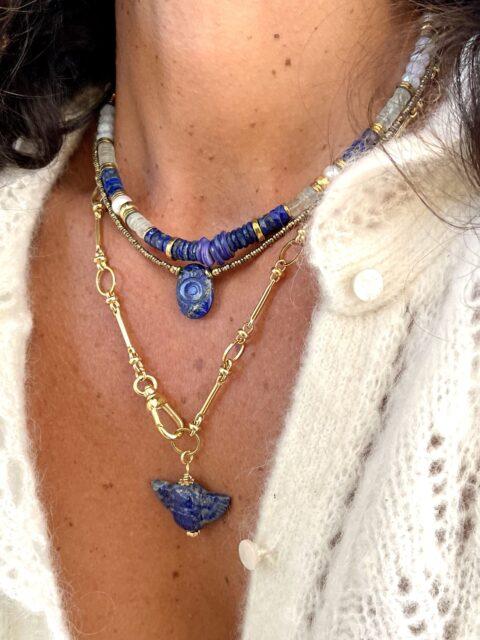 collier Horus est un ras de cou en hématites très fines très lumineuses or et un oeil sculpté en pierre au centre
