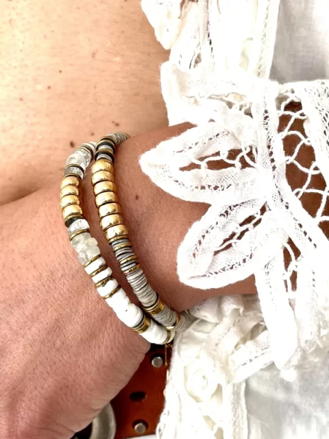 bracelet nymphe aigue marine est un bracelet puka style surfeur chic en perles heishi en pierre d'aigues-marines marine à facettes et coquillages blanc avec une cartouche centrale en perles or