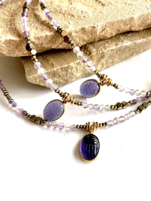 collier ras de cou khepri améthyste est un collier tout en pierres fines d'améthyste avec en son centre un médaillon serti en forme de scarabée en améthyste