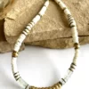 collier-nymphe-aigue-marine_2 colier nymphe aigue marine est un collier puka style surfeur chic en coquillages blanc et perles heishi aigue marine à facettes et cartouche de perles centrales or