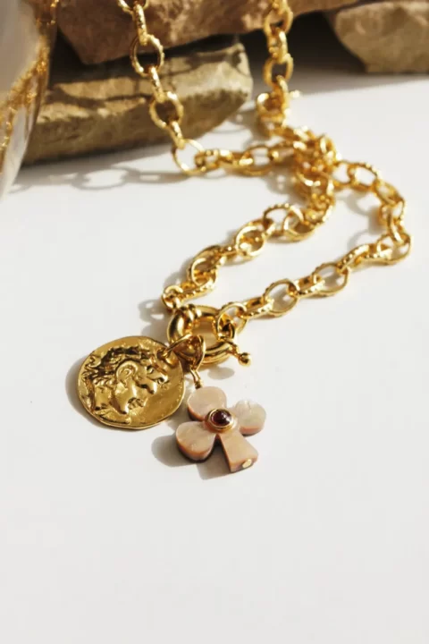 collier lucky grenat nacre est un collier grosse maille doré à l'or fin 24k, avec un fermoir bouée xl et 2 pendentifs porte bonheur. Un trèfle en nacre rose et coeur grenat et une médaille grec ancienne