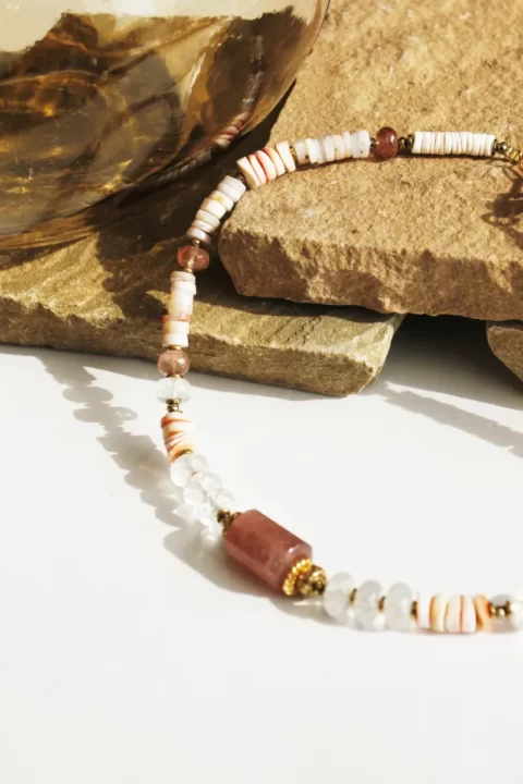collier kalinga quartz fraise est un collier ras de cou de style puka surfeur chic avec des pierres heishi en opale rose, quartz rose et coquillage et une cartouche centrale en quartz fraise