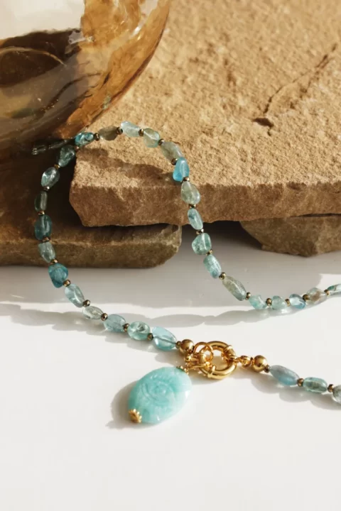 collier saba apatite oeil amazonite est un collier mi long tout en pierre d'apathie avec un fermoir bouée xl et un pendentif oeil sculpté en amazonite bleu