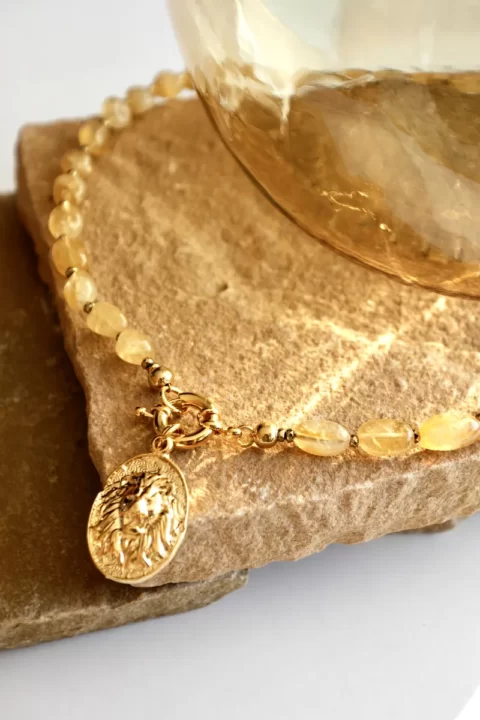 collier saba citrine est un collier ras de cou avec des pierres de citrine et un fermoir bouée ainsi qu'un médaillon plaqué or tête de lion ancien