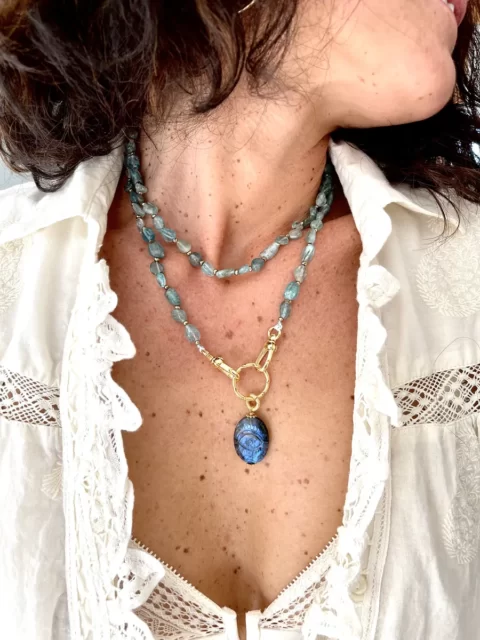 sautoir Lakshmi apatite est un long sautoir tout en pierre d'apathie et un médaillon en labradorite sculpté en forme d'oeil de protection bleu